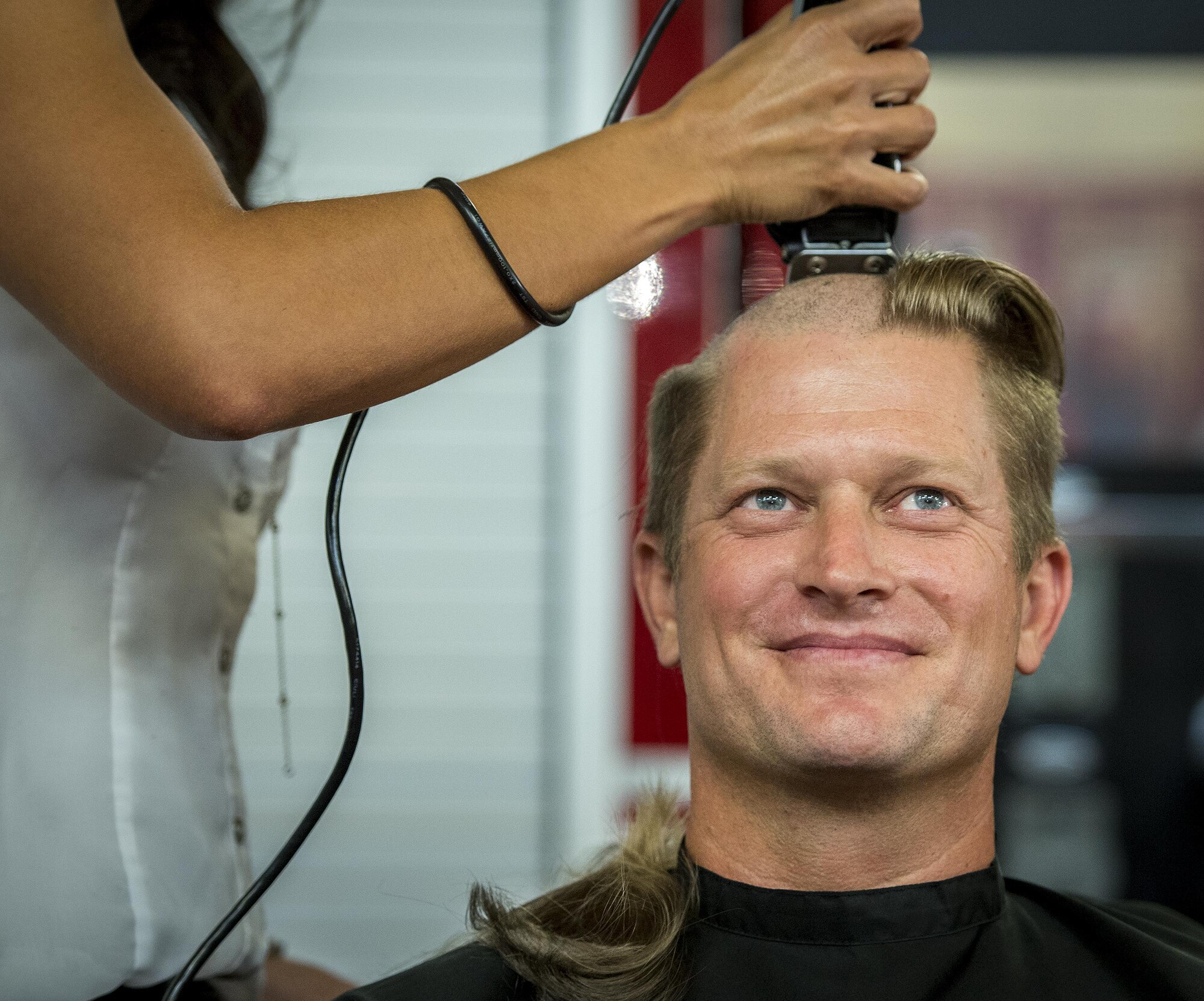 Robert Manby, a 96th Test Wing firefighter, receives a very close shave June 8 at Eglin Air Force Base, Fla.  Approximately 20 firefighters shaved their heads to raise awareness and funds for their crew mate, Terrance Curry, whose battled cancer continuously for 11 months.  (U.S. Air Force photo/Samuel King Jr.)