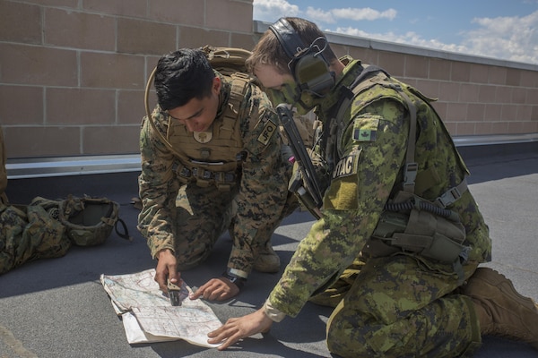 Cpl. Daniel A. Reyes (left), a joint fires observer with 3rd Brigade, 3rd Air Naval Gunfire Liaison Company, Force Headquarters Group, Marine Forces Reserve, kneels alongside Canadian Army Capt. Ethan McDonald (right), a joint terminal attack controller with Y Battery, 2nd Regiment, Royal Canadian Horse Artillery and points out target coordinates on a map at Canadian Manoeuvre Training Center, in Wainwright, Alberta, Canada, during exercise Maple Resolve 17, May 26, 2017. During the exercise the Marines from 3rd ANGLICO worked with the Canadian Army, calling simulated artillery to preplanned targets.