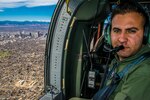 During a flight from Buckley Air Force Base, and traveling over downtown Denver, Sgt. Hazem Al-Qaise, an RJAF crew chief, takes his position as a crew chief, in the jump seat, March 16, 2017. Members of rotory-wing aviation units from the Royal Jordanian Air Force and the Colorado Army National Guard share knowledge about the UH-60 Black Hawk and sling-load operations. The RJAF members traveled to Colorado as part of the National Guard State Partnership Program. 