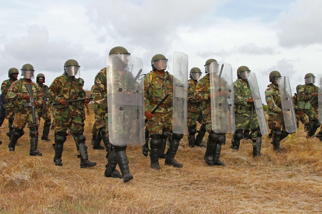 Members of the Antigua, St. Kitts, St. Vincent, and Grenada police forces march toward a staged riot during a training event in Bushy Park, Barbados for Exercise Tradewinds, June 10, 2017. Military personnel and civilians from 20 countries are participating in this year’s exercise in Barbados and Trinidad & Tobago, which runs from June 6-17. (U.S. Army National Guard photo by Sgt. Renee Seruntine)