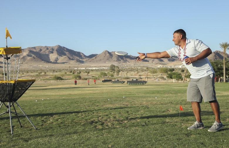 Staff Sgt. Stephen Chevez, radio chief, Marine Corps Communication-Electronics School, attempts to throw a Frisbee into a goal, during the annual Pro and Glow golf tournament hosted by Marine Corps Community Services at the Desert Winds Golf Course aboard the Marine Corps Air Ground Combat Center Twentynine Palms, Calif., June 2. MCCS hosted the event, which featured presentations from a professional golfer and a professional Frisbee golfer for the purpose of introducing Combat Center patrons to the sports and showcasing the golf and Frisbee golf courses aboard the base.