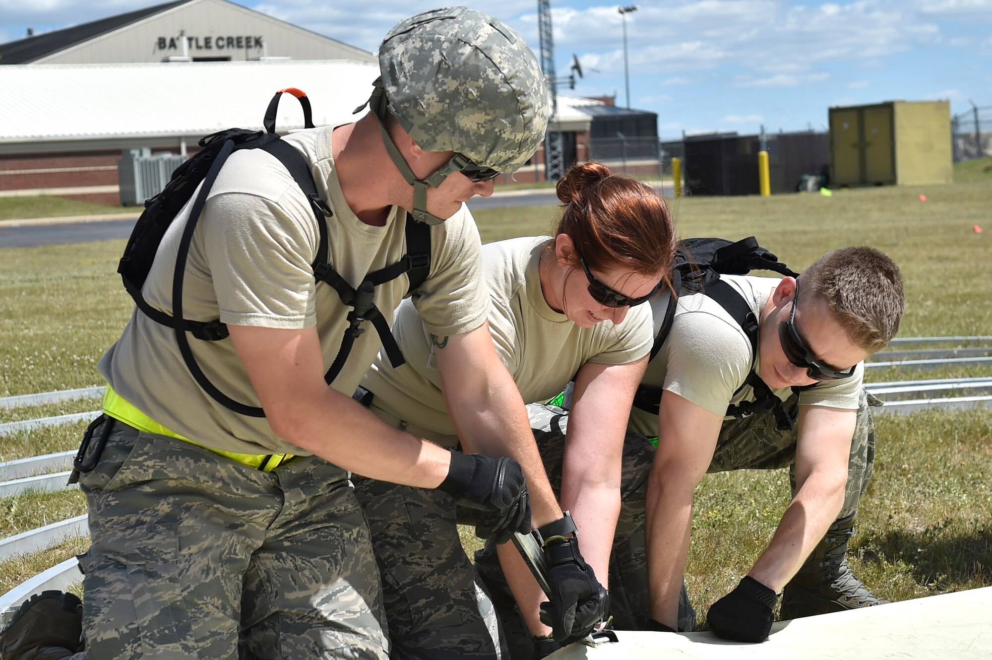 Staff Sgt. Benjamin Guyton, 921st Contingency Response Squadron mobile C2 controller, Capt. Sarah Fry, 60th Aerospace Medicine Squadron public health officer, and Senior Airman Nicholas Wunsch, 921st Contingency Response Squadron vehicle maintainer, work together to set-up tents during Exercise Turbo Distribution 17-02, June 7, 2017, at Battle Creek Air National Guard Base, Mich.  Turbo Distribution 17-2 is an U.S. Transportation Command exercise designed to assess the Joint Task Force-Port Opening's ability to deliver and distribute cargo during humanitarian and disaster relief operations. (U.S. Photo by Tech. Sgt. Liliana Moreno/Released)