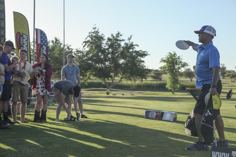 Chris Brophy, professional disc golfer, explains how professionals grip the Frisbee in order to get the most distance during the annual Pro and Glow golf tournament hosted by Marine Corps Community Services at the Desert Winds Golf Course aboard the Marine Corps Air Ground Combat Center Twentynine Palms, Calif., June 2. MCCS invited Brophy to be a golf demonstrator at the event in order to show Combat Center patrons different ways to expand their golfing talents..