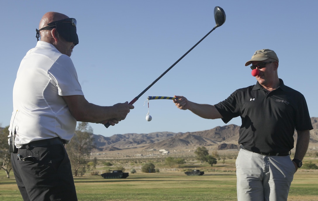 Peter Johncke, trick shot master, performs a trick shot during the Pro and Glow golf tournament hosted by Marine Corps Community Services at the Desert Winds Golf Course aboard the Marine Corps Air Ground Combat Center Twentynine Palms, Calif., June 2. MCCS invited Johncke to be a golf demonstrator at the event in order to show Combat Center patrons different ways to expand their golfing talents.