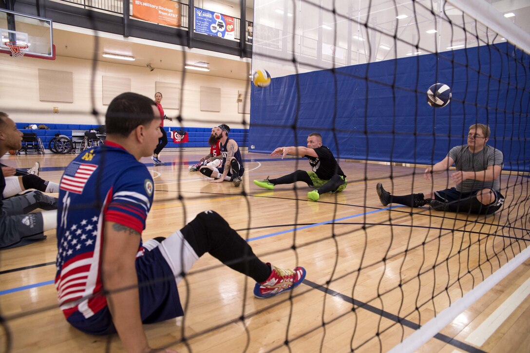 Retired Navy Chief Yeoman Javier Rodriguez practices sitting volleyball drills with Team Navy teammates during the Navy Wounded Warrior Walter Reed Adaptive Sports training camp in Bethesda, Md., June 10, 2017. Navy photo by Petty Officer 2nd Class Charlotte C. Oliver