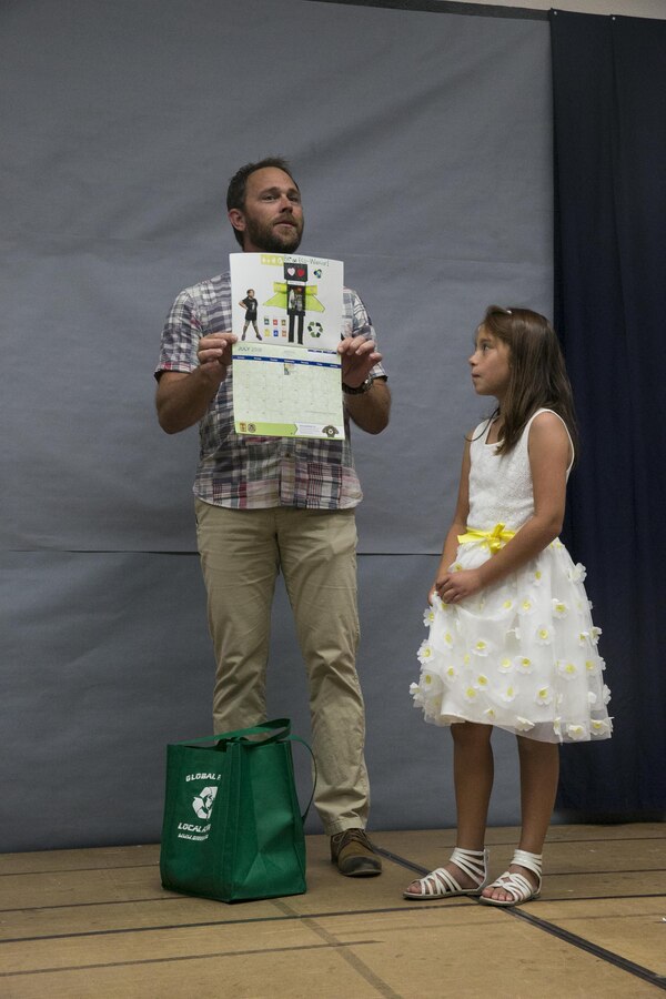 Chris Elliott, water resource manager, displays the poster contest entry by Isabella Zendejas, 8, daughter of Petty Officer 1st Class Ismael Zendejas, personnel specialist, Robert E. Bush Naval Hospital, in the 2018 NREA Earth Day calendar at Condor Elementary aboard the Marine Corps Air Ground Combat Center, Twentynine Palms, Calif., June 6, 2017. The purpose of the poster contest was to promote creativity amongst the children while spreading awareness of Earth Day. (U.S. Marine Corps photo by Cpl. Dave Flores)