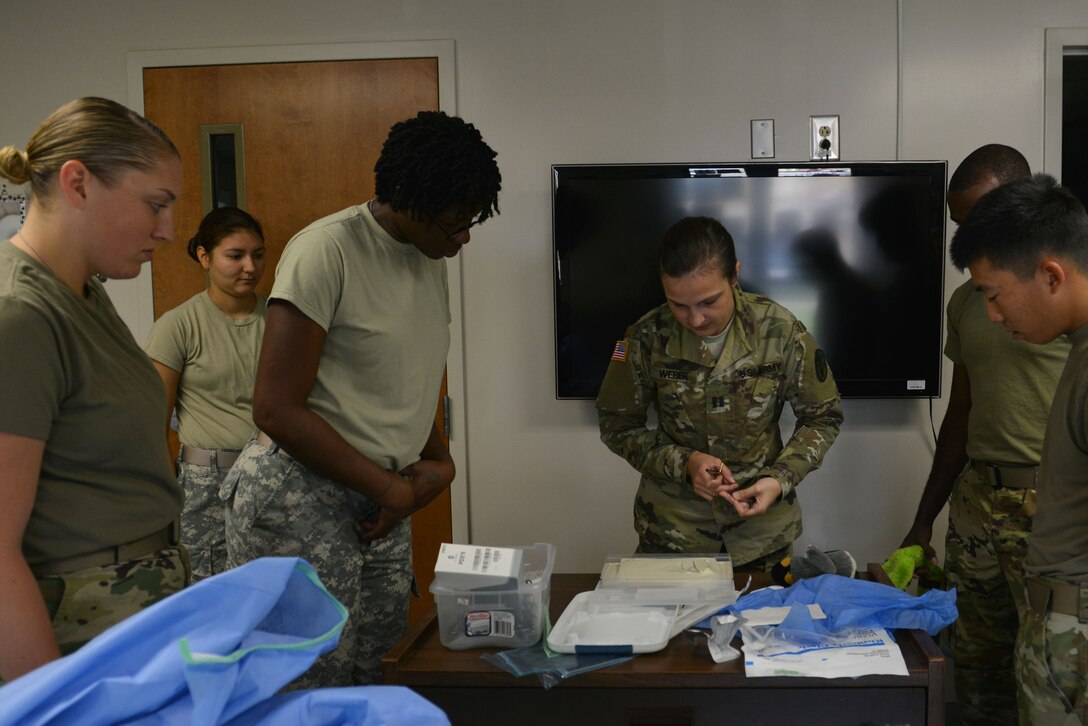 U.S. Army Capt. Katherine Weber, Shaw Veterinary Treatment Facility (VTF) officer in charge, trains Soldiers on suture techniques at the Shaw Air Force Base, S.C., VTF, June 1, 2017. During “Operation Repair the Bear” led by the Shaw VTF staff, Soldiers learned to use needle drivers and forceps to create sutures. (U.S. Air Force photo by Airman 1st Class Destinee Sweeney)