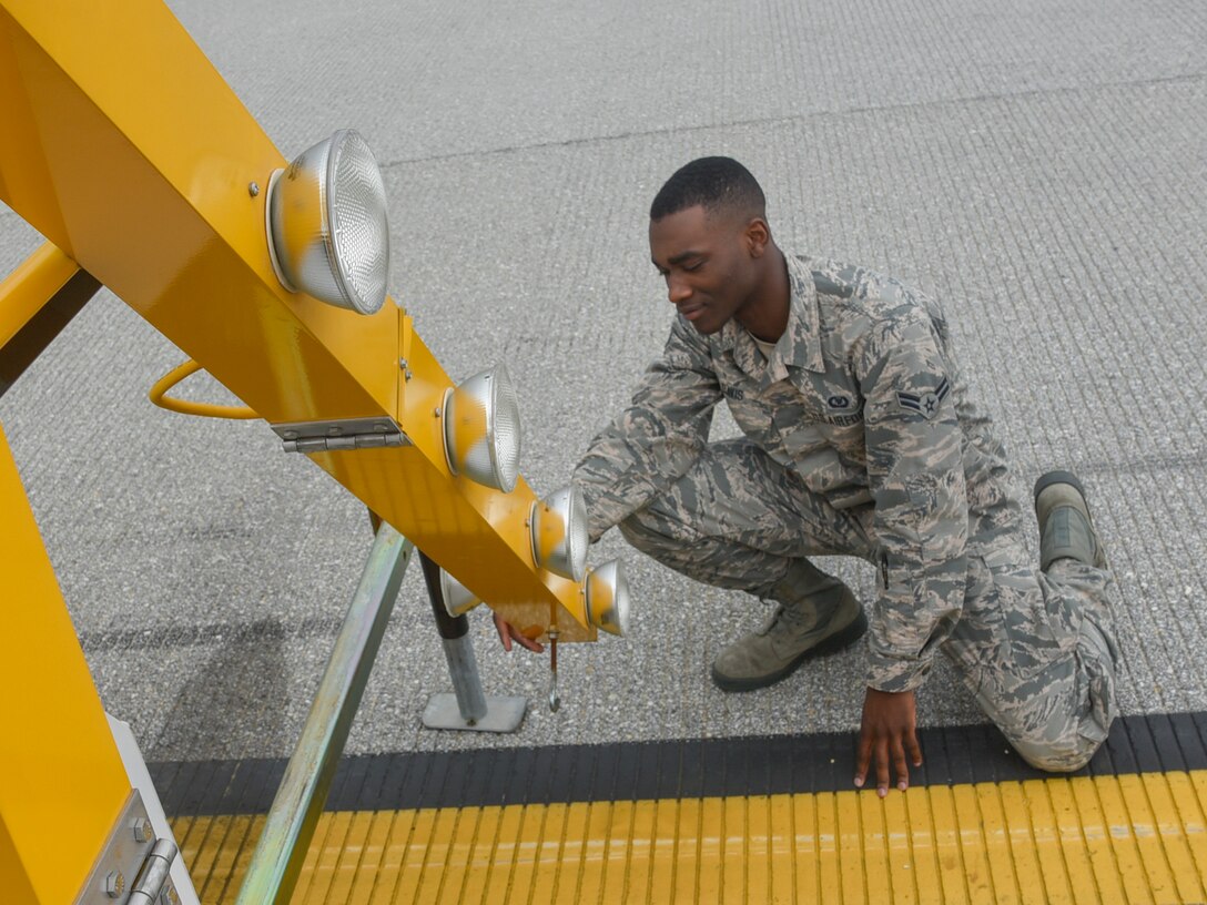 Airman 1st Class Isaiah Davis, 89th Operations Support Squadron airfield manager, checks the functionality of a runway signal at Joint Base Andrews, Md., June 7, 2017. The sign communicates to the arriving aircrew that a part of the flightline is closed due to construction and helps prevent accidents. (U.S. Air Force photo by Airman 1st Class Valentina Lopez)