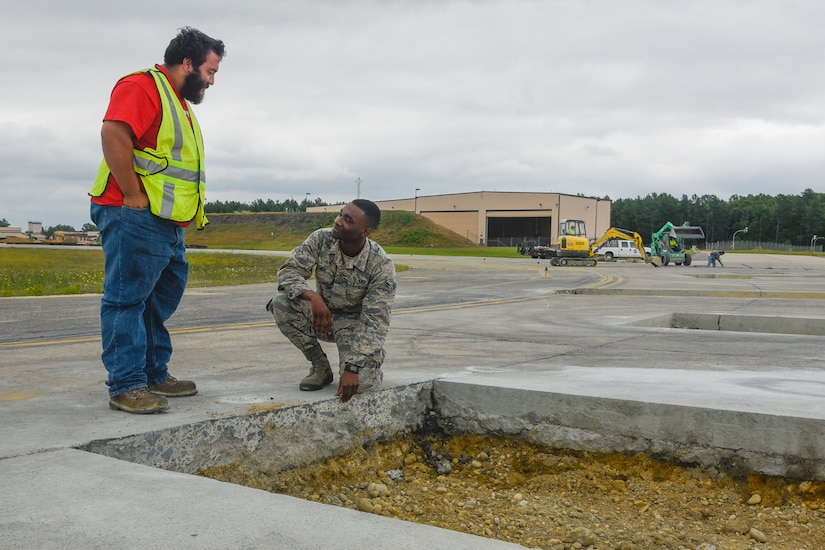Airman 1st Class Isaiah Davis, right, 89th Operations Support Squadron airfield manager, works with construction personnel during flightline repairs at Joint Base Andrews, Md., June 7, 2017. Airfield management coordinates all flightline operations with many units including air traffic control, security forces and civil engineers.  (U.S. Air Force photo by Airman 1st Class Valentina Lopez)