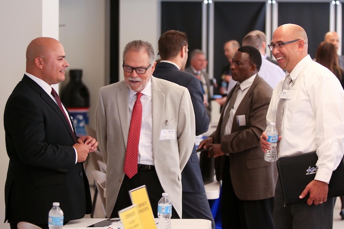 Tomas Beauchamp, Naval Surface Warfare Center (NSWC), Corona Division Corporate Operations Department head, left, chats with Jim Savage, JSL Technologies executive vice president, and Clifford Martin, ICI Services project manager, during Industry Day at Corona City Hall. The event, organized in cooperation with Riverside Community College District Procurement Assistance Center, included a keynote presentation by Emily Harman, Department of the Navy Office of Small Business Program director, a forecast of NSWC Corona future contracting/subcontracting opportunities as well as a series of meet-and-greet sessions for suppliers to network with technical department personnel.