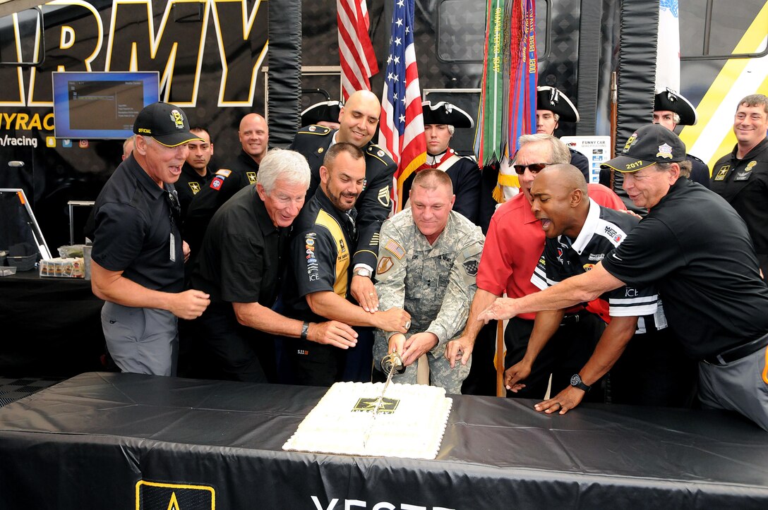 Maj. Gen. Troy D. Kok, commanding general of the U.S. Army Reserve’s 99th Regional Support Command, headquartered at Joint Base McGuire-Dix-Lakehusrt, New Jersey, helps cut the cake June 10 with the help of Don Schumacher Racing.  The cake cutting was part of “Army Day At The Races” at Old Bridge Township Raceway Park in Englishtown, New Jersey.  Tony Schumacher (immediate left of Kok) drives the U.S. Army top fuel dragster.