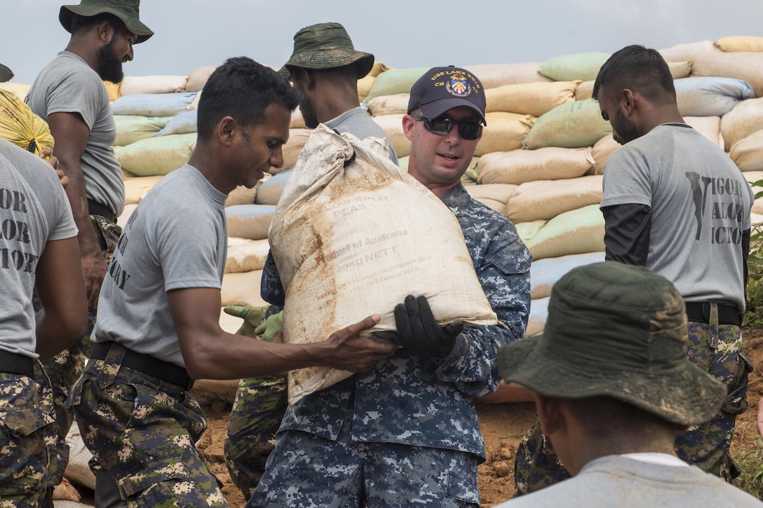 Navy Petty Officer 2nd Class Jason McEntire works with Sri Lankan marines to repair levees in Matara, Sri Lanka, June 12, 2017, during humanitarian assistance operations following severe flooding and landslides that devastated many regions of the country. Navy photo by Petty Officer 2nd Class Joshua Fulton