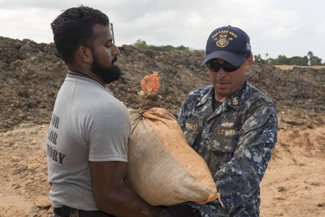 Navy Chief Oscar Gonzalez works with a Sri Lankan marine to repair levees in Matara, Sri Lanka, June 12, 2017, during humanitarian assistance operations following severe flooding and landslides that devastated many regions of the country. Navy photo by Petty Officer 2nd Class Joshua Fulton