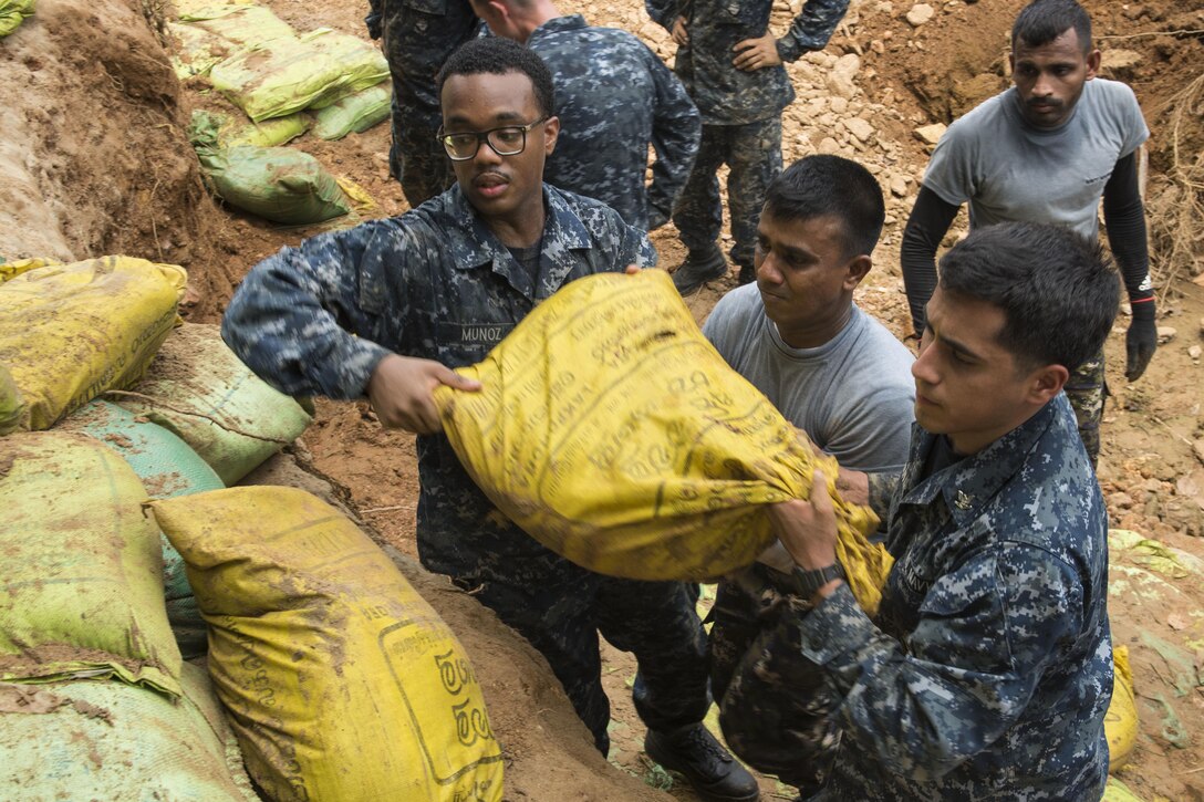 Sailors work with Sri Lankan marines to repair a levee in Matara, Sri Lanka, June 12, 2017, during humanitarian assistance operations following severe flooding and landslides in the country. Navy photo by Petty Officer 2nd Class Joshua Fulton