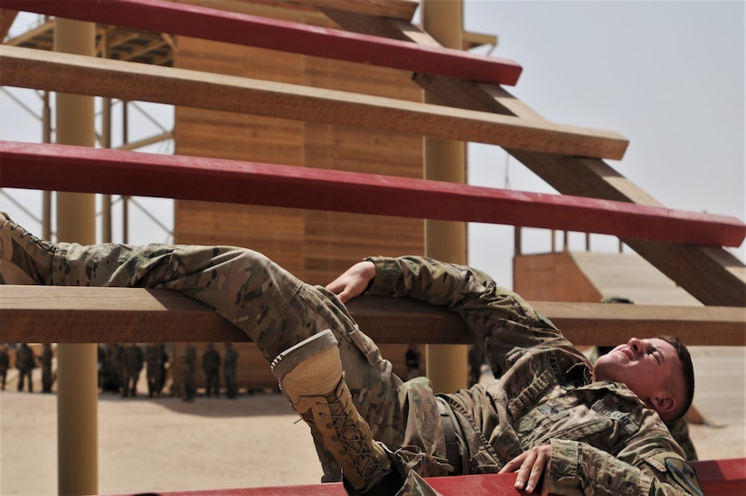 Spc. Thomas Jancosek, a Soldier with 3rd Armored Brigade Combat Team, 1st Cavalry Division, competitor in the U.S. Army Central Best Warrior, perseveres through one of the last obstacles on the air assault obstacle course at Camp Buehring, Kuwait, May 23. Soldiers had to climb, crawl, and swing their way to the end of the course. (Photo by U.S. Army Sgt. Kelly Gary, 29th Infantry Division Public Affairs)