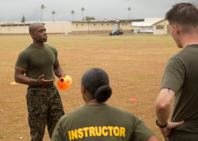 Gunnery Sgt. Dimyas Perdue, the staff non-commissioned officer-in-charge of the Force Fitness Readiness Center, explains the next exercise during the Force Fitness Instructor Promotion Tour practical demonstration on Marine Corps Base Hawaii June 8, 2017. The program is based on five tiers of exercises, with the intensity gradually increasing from dynamic warm-ups to the demanding “optimal finisher.” (Photo by Lance Cpl. Luke Kuennen)