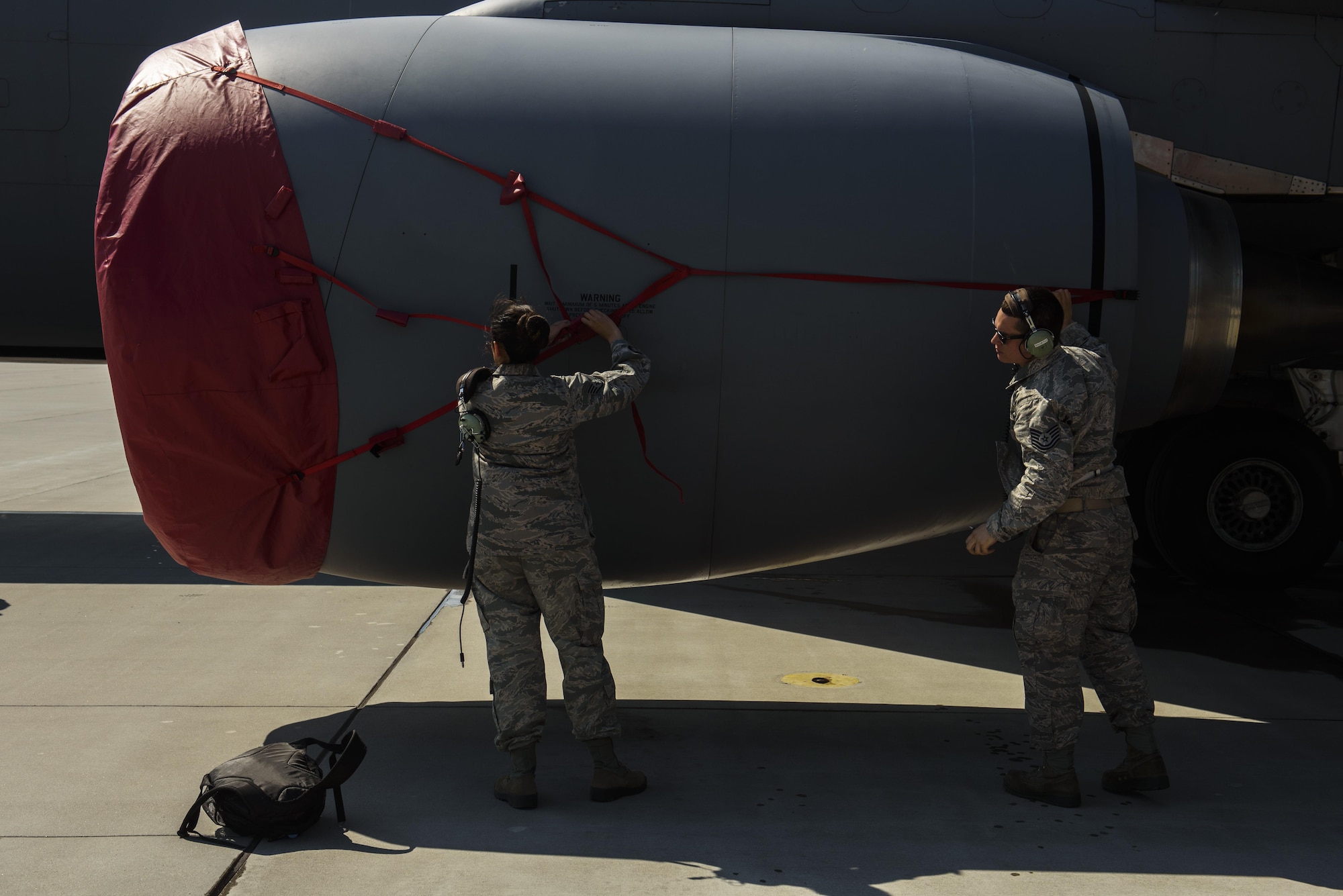 Staff Sgt Sandra Henriquez, left, 459th Aircraft Maintenance Squadron aero repair, and Tech. Sgt. Aaron Frank, right, 459th Aircraft Maintenance Squadron avionics comm/nav technician, both are part of the Total Force Citizen Airmen team puts the covers over a KC-135R Stratotanker engine during BALTOPS exercise at Powidz Air Base, Poland, June 12, 2017. The exercise is designed to enhance flexibility and interoperability, to strengthen combined response capabilities, as well as demonstrate resolve among Allied and Partner Nations' forces to ensure stability in, and if necessary defend, the Baltic Sea region. (U.S. Air Force photo by Staff Sgt. Jonathan Snyder)
