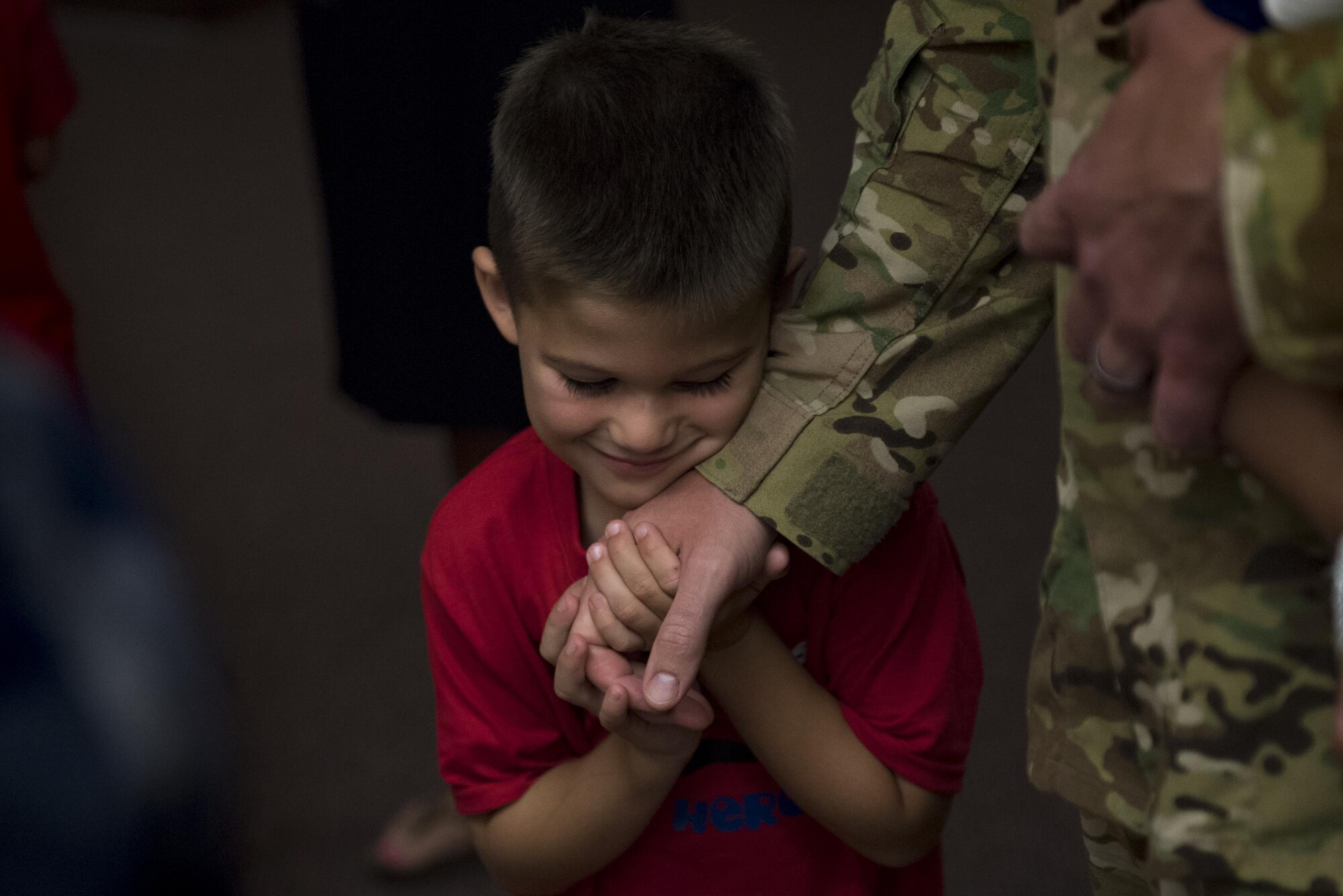 Luke Rynbrandt, holds the hand of his father, Capt. Kevin Rynbrandt, 41st Rescue Squadron HH-60G Pave Hawk pilot, as he returned home from a deployment, June 8, 2017, at Moody Air Force Base, Ga. The 41st and 71st Rescue Squadrons were recently deployed to Southwest Asia where they provided combat search and rescue capabilities in support of Operation Inherent Resolve. (U.S. Air Force photo By Airman 1st Class Daniel Snider)