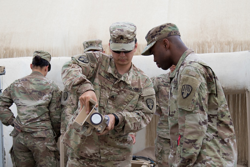 Sgt. Thomas Lee, a Flushing, N.Y. resident, trains Sgt. Passely Hutchinson, a Brooklyn, N.Y. resident, both with the 369th Sustainment Brigade, in the use of a satellite communications system at Camp Arifjan Kuwait, May 20, 2017. Satellite training is part of the brigade’s Small Unit Leader Training program. (U.S. Army photo by Sgt. Cesar E. Leon)