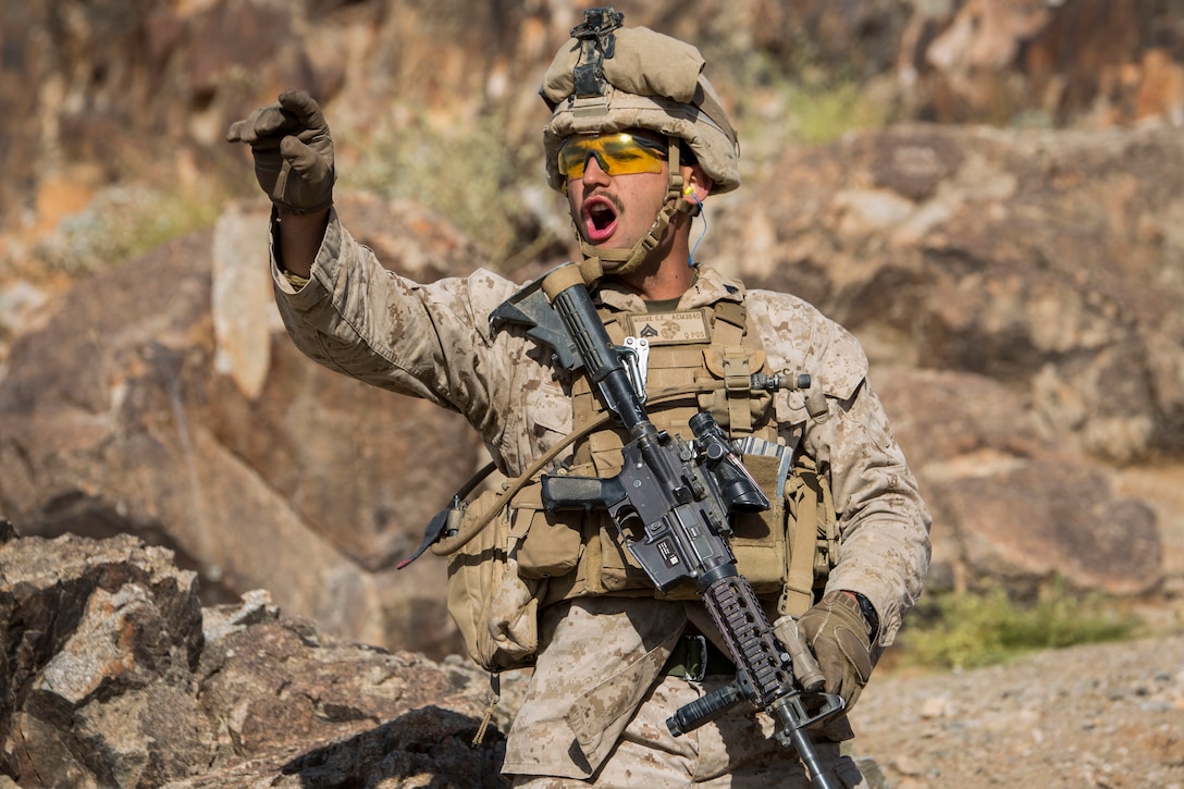 MARINE CORPS AIR GROUND COMBAT CENTER TWENTYNINE PALMS, California – Cpl. Charles Moore, a squad leader for Weapons Platoon, Alpha Company, 1st Battalion, 8th Marine Regiment, passes orders off to machine gun emplacments during a reinforced company assault at Range 400 aboard Marine Corps Air Ground Combat Center, Twentynine Palms, California, May 7, 2017. The Marines conducted a company level assault reinforced by machine guns, vehicles, mortars and snipers as part of Integrated Training Exericse 3-17. Integrated Training Exercise is a training evolution conducted five times a year to enhance the lethality and co-operability between the four elements of a Marine Air Ground Task Force. (U.S. Marine Corps photo by Cpl. Jesus Sepulveda Torres)