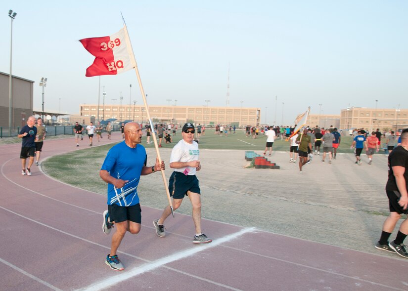 Staff Sgt. Kenny Bharose, of HHC 369th, and Master Sgt. Ruben Delgado, of the 369th Sustainment Brigade cross the finish line in the inaugural Harlem Hellfighter 5K run, held at Camp Arifjan, Kuwait on June 2, 2017. The event was held to celebrate the 104th anniversary of the formation of the historic New York National Guard unit. The unit was given their historic nickname “Hellfighters” by their German opponents in WWI for their remarkable prowess on the battlefield. (U.S. Army photo by Sgt. Jeremy Bratt)