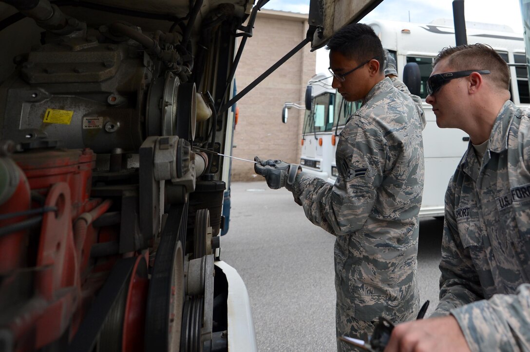 U.S. Air Force Staff Sgt. Tristan Short, 20th Logistics Readiness Squadron (LRS) ground transportation craftsman, right, certifies Airman 1st Class Eric Michael, 20th LRS ground transportation apprentice, on bus mechanics at Shaw Air Force Base, S.C., June 12, 2017. Ground transportation Airmen are certified on inspecting and operating various vehicles throughout their careers to include buses, vans and flatbed trailers. (U.S. Air Force photo by Airman 1st Class Christopher Maldonado)