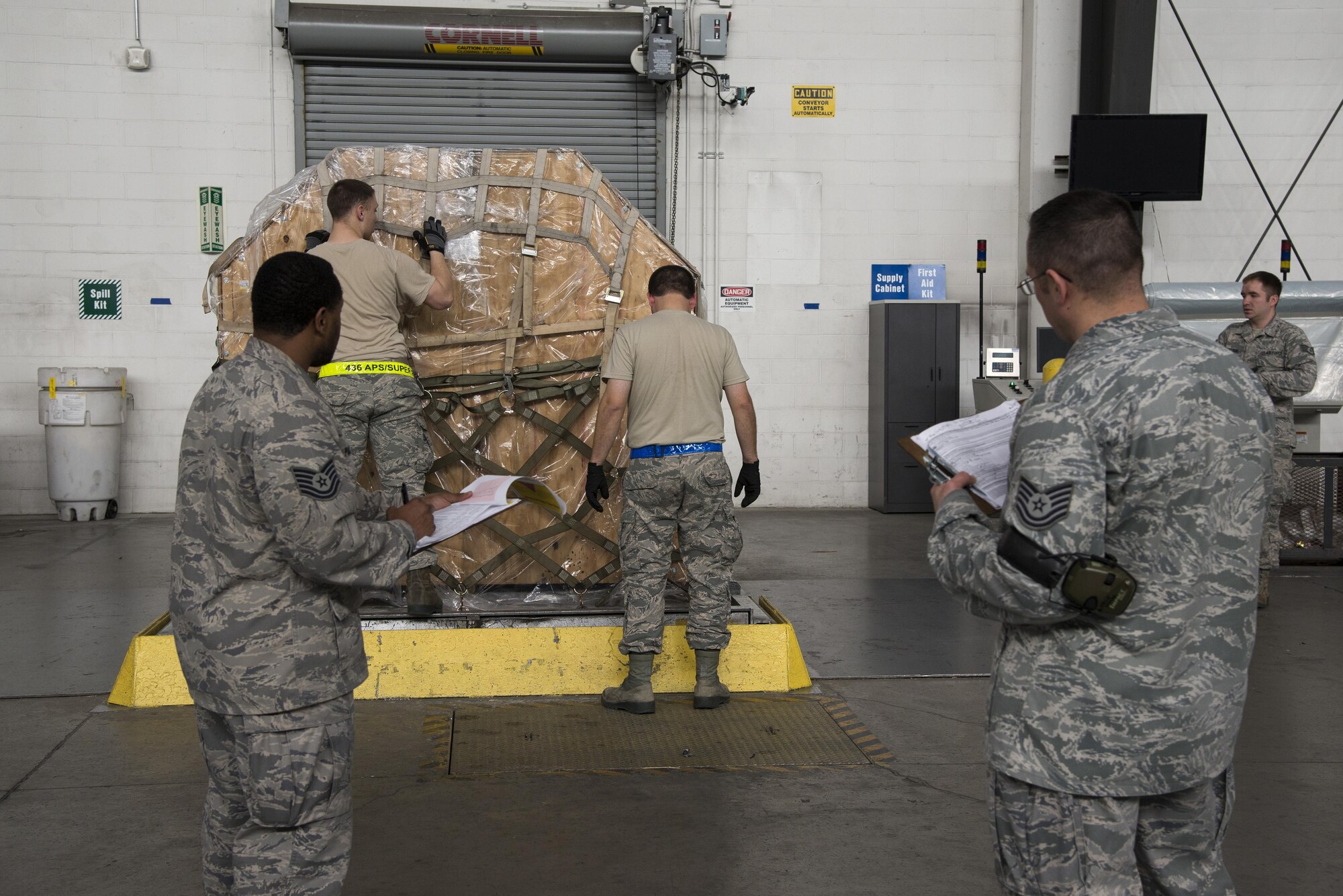 Tech. Sgts. Randie Page and Jeffrey Kach, 436th Aerial Port Squadron Air Transportation Standardization and Evaluations Program evaluators, observe Airmen build a pallet Jan. 12, 2017, at the aerial port on Dover Air Force Base, Del. The ATSEP program was established in 2016 to realign the existing evaluations program with the Air Force Inspection System. (U.S. Air Force photo by Senior Airman Aaron J. Jenne)