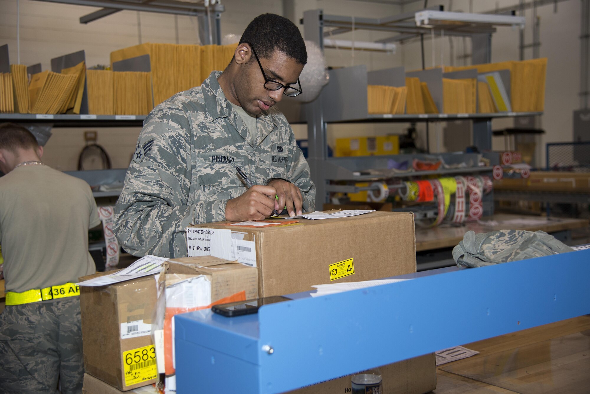 Senior Airman Gerard Pinckney, 436th Aerial Port Squadron traffic management specialist, calculates dimensions needed for boxing an item Jan. 12, 2017, at the aerial port on Dover Air Force Base, Del. The squadron has a box-making machine, which allows improved precision packing of cargo. (U.S. Air Force photo by Senior Airman Aaron J. Jenne)