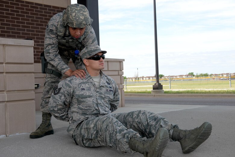 Airman 1st Class Emmanuel Morgan, a response force member assigned to the 28th Security Forces Squadron, arrests Tech. Sgt. Ty Orr, a manpower craftsman assigned to the 28th Force Support Squadron, during an exercise at Ellsworth Air Force Base, S.D., June 7, 2017. During the exercise, Morgan and Orr executed detainment measures in response to a simulated terrorist attack at one of the base’s entry control points. (U.S. Air Force photo by Staff Sgt. Hailey Staker)