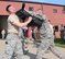 932nd Security Forces Squadron members with protective shields brace for impact from pressure applied by fellow squadron member during a baton blocking and attacking training class, at Scott Air Force Base, Illinois, June 4, 2017.   Airmen later volunteered to be in the highly padded RedMan suit to better appreciate the mission and training of the 932nd AW SFS team. It was all about training, unit bonding, and outdoor crowd control practice along with aggressor experience. (U.S. Air Force photo by Lt. Col. Stan Paregien)