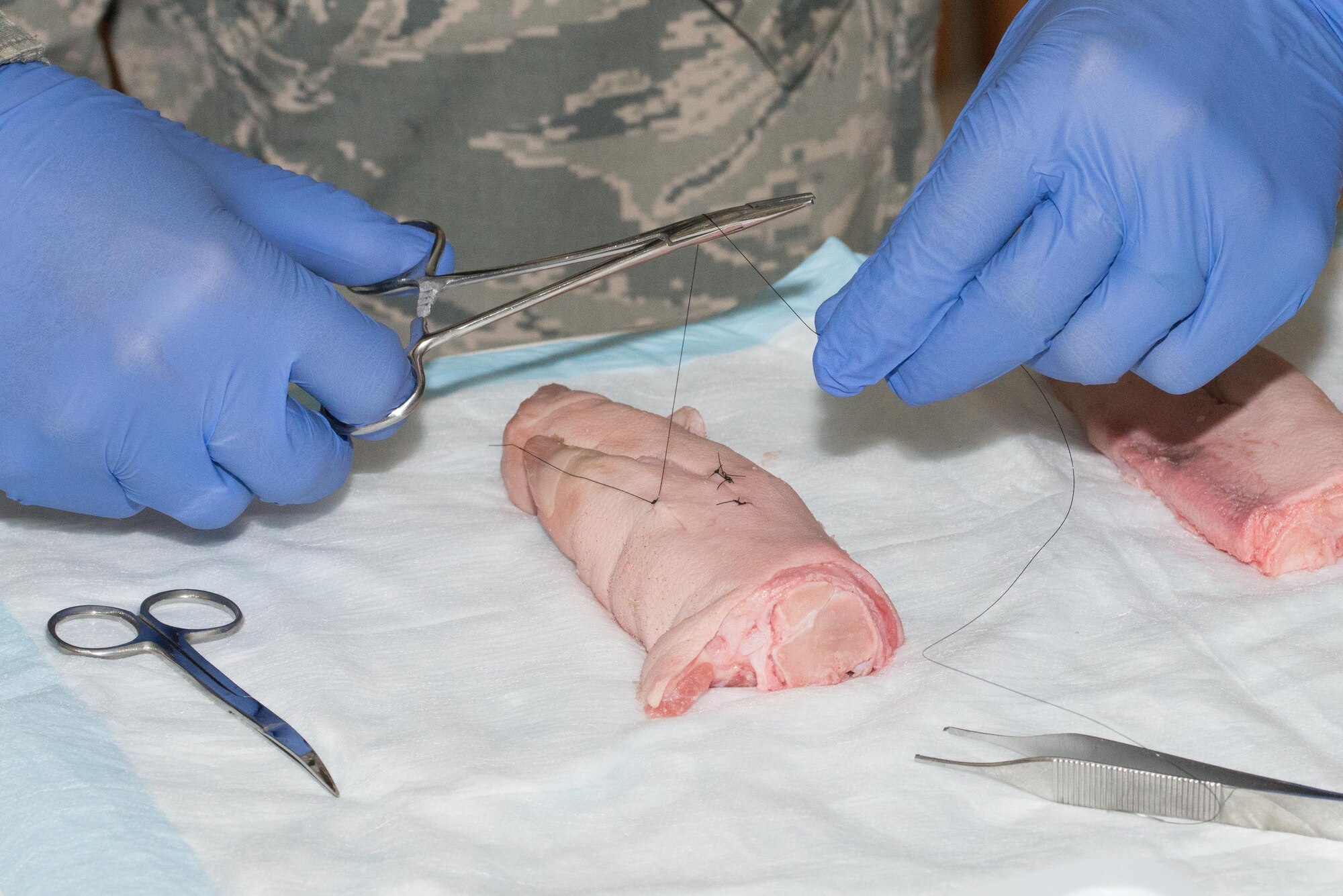 A U.S. Airman practices suturing  during a 36th Medical Group training day June 8, 2017, at Andersen Air Force Base, Guam. To maintain proficiency, the 36th and the 159th MDG, Naval Air Station Joint Reserve Base New Orleans, La., trained readiness skills that are not often practiced in a clinical setting. (U.S. Air Force photo by Airman 1st Class Jacob Skovo)