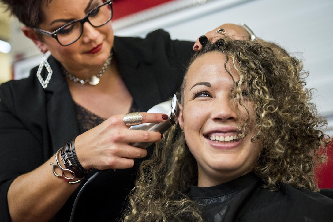 Avalon Cummings, a firefighter assigned to the 96th Test Wing firefighter, gets her head shaved at Eglin Air Force Base, Fla., June 8, 2017. About 20 firefighters at the base shaved their heads to raise awareness and funds for a crew mate with cancer. Air Force photo by Samuel King Jr.