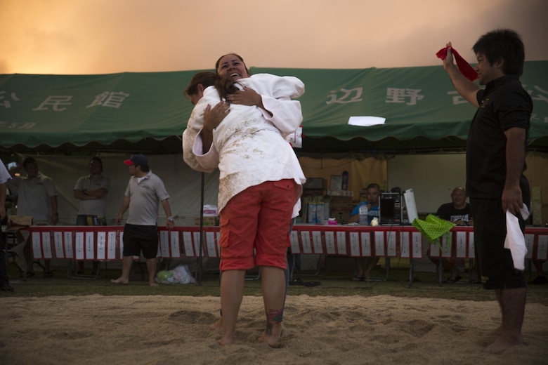Two competitors embrace each other after their bout, June 10, 2017, during the annual Henoko Okinawa-Style Sumo Tournament, at Mae-No-Hama Field, in Henoko, Okinawa, Japan. During a bout, competitors try to earn points by making their opponent fall into the dohyo, or sandy pit, without striking or letting go of each other’s belts. The first to gain two points is the victor. Okinawa-style sumo wrestling, also known as kakuriki, is a combination of western wrestling and traditional Japanese sumo and judo, according to Fumio Iha, Camp Schwab’s community relations specialist. (U.S. Marine Corps photo by Lance Cpl. Andy Martinez)