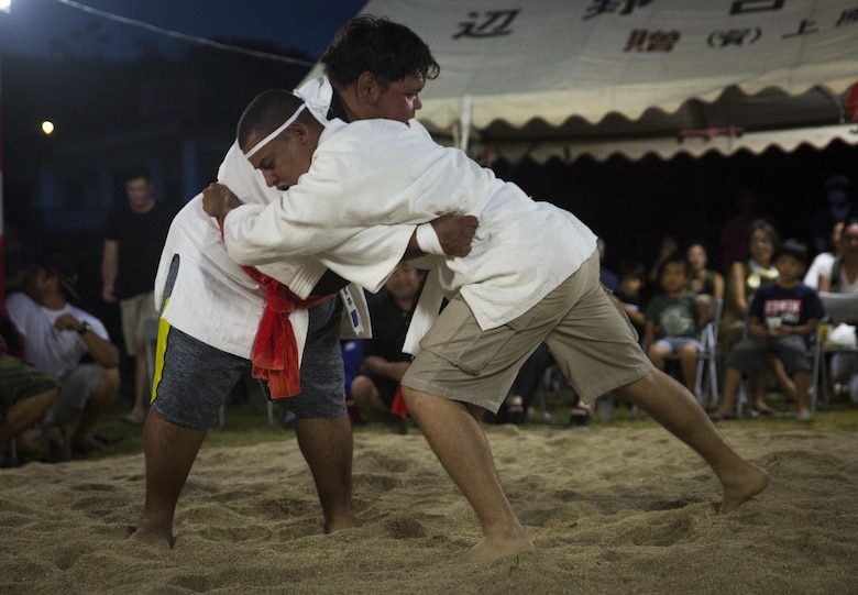 Private First Class Jose Berries (right) attempts to take down his opponent, June 10, 2017, during the annual Henoko Okinawa-Style Sumo Tournament, at Mae-No-Hama Field, in Henoko, Okinawa, Japan. During a bout, competitors try to earn points by making their opponent fall into the “dohyo,” or sandy pit, without striking each other or letting go of each other’s belts. The first to gain two points is the victor. Berries is a native of Holyoke, Massachusetts, and a motor vehicle operator with Headquarters Battalion, 3rd Marine Division, III Marine Expeditionary Force. (U.S. Marine Corps photo by Lance Cpl. Andy Martinez)