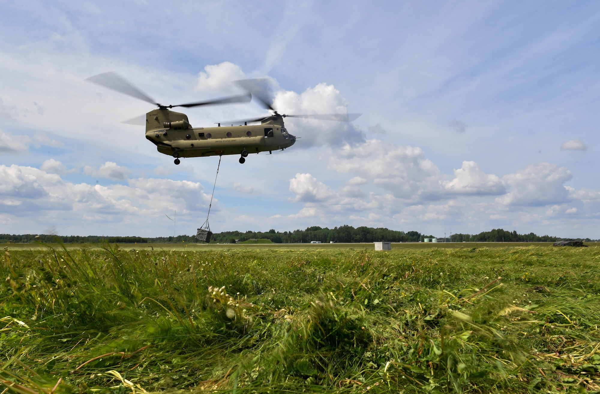 A U.S. Army CH-47 Chinook helicopter lifts a bundle into the air for the U.S. Air Force 435th Contingency Response Group’s sling load operation during exercise Saber Strike 17 at Lielvarde Air Base, Latvia, June 10, 2017. The 435th CRG Airmen worked alongside the U.S. Army and NATO military members throughout the exercise. Saber Strike 17 continues to increase participating nations’ capacity to conduct a full spectrum of military operations.  (U.S Air Force photo by Senior Airman Tryphena Mayhugh)