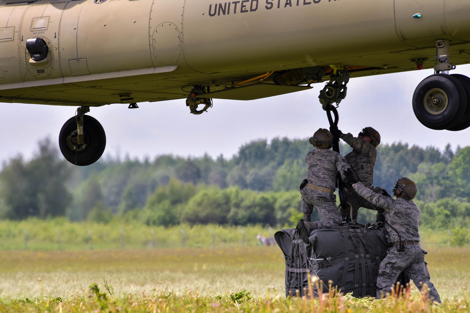 U.S. Air Force Airmen assigned to the 435th Contingency Response Group hook a bundle to the bottom of a U.S. Army CH-47 Chinook for the 435th CRG’s sling load operation during exercise Saber Strike 17 at Lielvarde Air Base, Latvia, June 10, 2017. The Chinook raised and then set down the bundle, allowing for a new team of 435th CRG Airmen to practice rigging the bundle next. The combined training opportunities that Saber Strike 17 provides greatly improve interoperability among participating NATO allies and key regional partners.  (U.S Air Force photo by Senior Airman Tryphena Mayhugh)