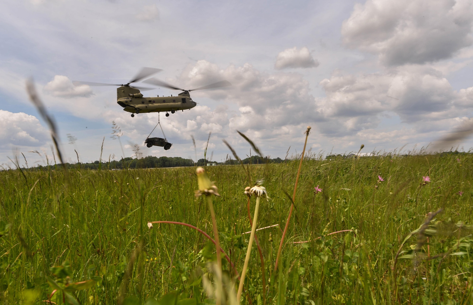 A U.S. Army CH-47 Chinook helicopter carries a high mobility multipurpose wheeled vehicle for the U.S. Air Force 435th Contingency Response Group’s sling load operation during exercise Saber Strike 17 at Lielvarde Air Base, Latvia, June 10, 2017. The 435th CRG Airmen worked alongside the U.S. Army and NATO military members throughout the exercise. Saber Strike 17 continues to increase participating nations’ capacity to conduct a full spectrum of military operations.  (U.S Air Force photo by Senior Airman Tryphena Mayhugh)