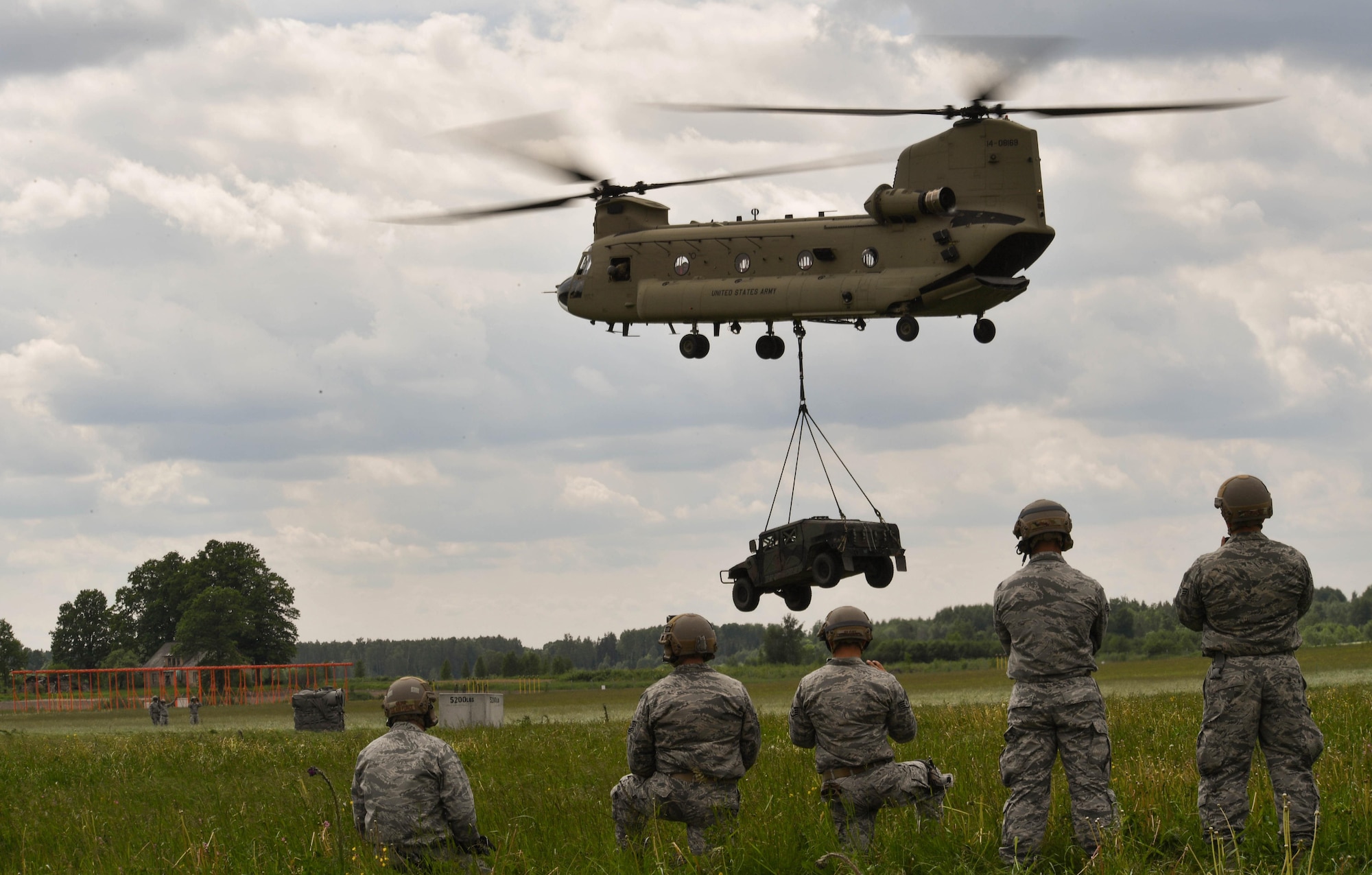 U.S. Air Force Airmen assigned to the 435th Contingency Response Group watch a high mobility multipurpose wheeled vehicle suspended from a U.S. Army CH-47 Chinook for the 435th CRG’s sling load operation during exercise Saber Strike 17 at Lielvarde Air Base, Latvia, June 10, 2017. The 435th CRG Airmen rigged the HUMVEE to the Chinook and were watching to make sure it had been rigged properly. Saber Strike 17 highlights the inherent flexibility of ground and air forces to rapidly respond to crises allowing for the right presence where it is needed, when it is needed. (U.S Air Force photo by Senior Airman Tryphena Mayhugh)