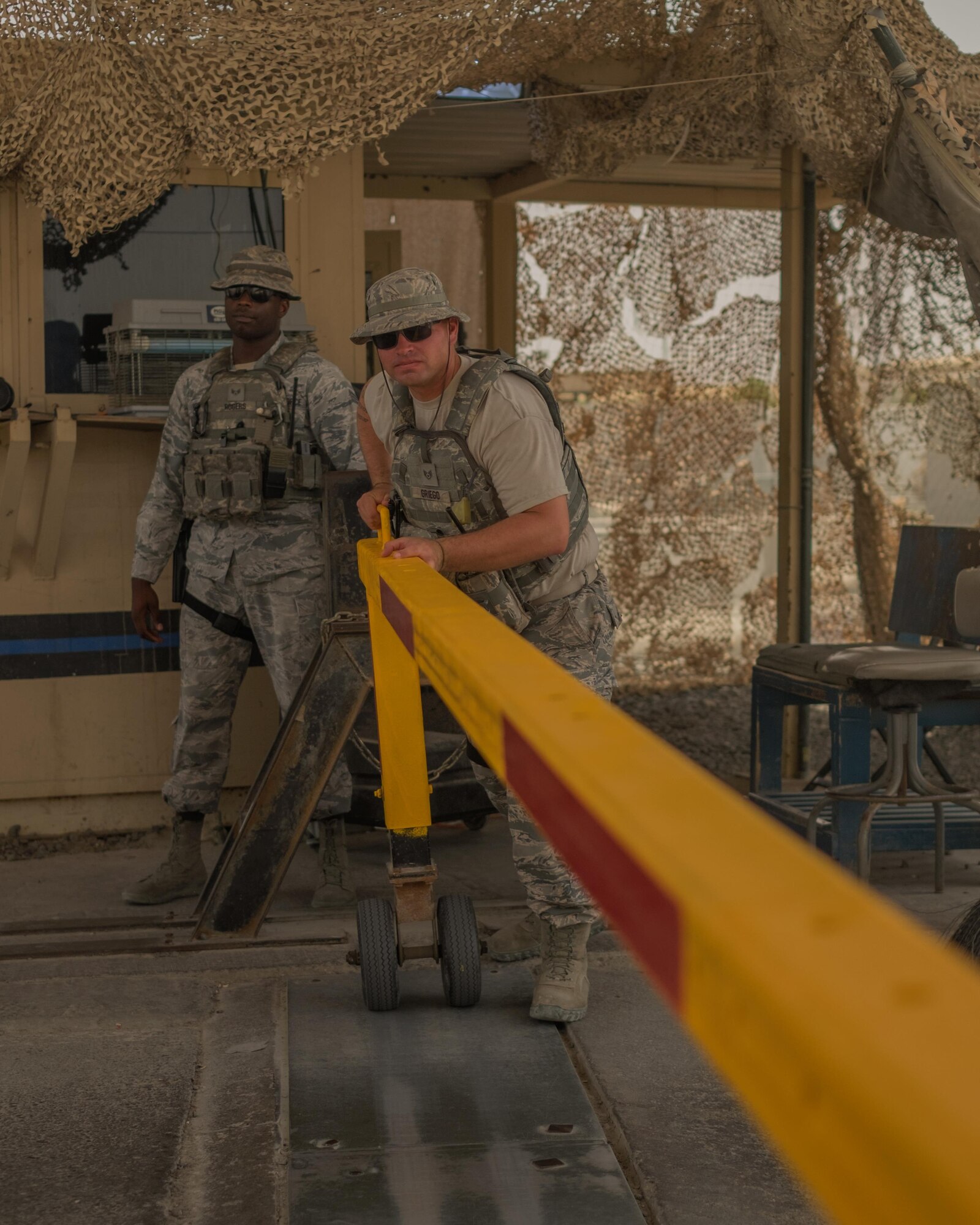 Senior Airman Brody, right, 380th Expeditionary Security Forces Squadron installation entry controller, opens a gate June 7, 2017, at an undisclosed location in southeast Asia. Airmen in the 380 ESFS serve a key role in physically defending the installation. (U.S. Air Force photo by Senior Airman Preston Webb)