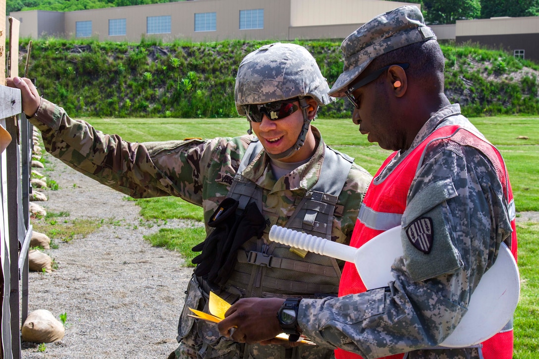 Army Sgt. Max Vasquez, a member of the New York National Guard, left, checks his target with a range safety officer during competition at Camp Smith Training Site, N.Y., June 3, 2017. Vasquez is assigned to the 187th Signal Company. Army National Guard photo by Spc. Jonathan Pietrantoni