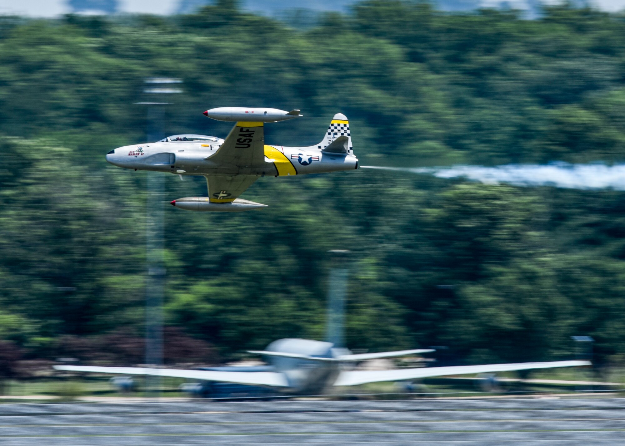 Gregory Colyer demonstrates combat maneuvers in the T-33 during the 100th Centennial Celebration Air Show, June 10, 2017, at Scott Air Force Base, Ill.  The two-place T-33 jet was designed for training pilots already qualified to fly propeller-driven aircraft. It was developed from the single-seat F-80 fighter by lengthening the fuselage about three feet to accommodate a second cockpit. (U.S. Air Force photo by Staff Sgt. Jodi Martinez)