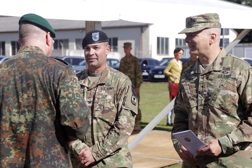 Incoming commander of the 361st Civil Affairs Brigade, Col. Bradley A. Heston (center) shakes hands with a Soldier from the German Bundeswehr (left) as Brig. Gen. Glenn A. Goddard, commanding general of the 353rd Civil Affairs Command (right), looks on after the brigade change of command ceremony Saturday, June 10, 2017 on Daenner Kaserne in Kaiserslautern, Germany. 