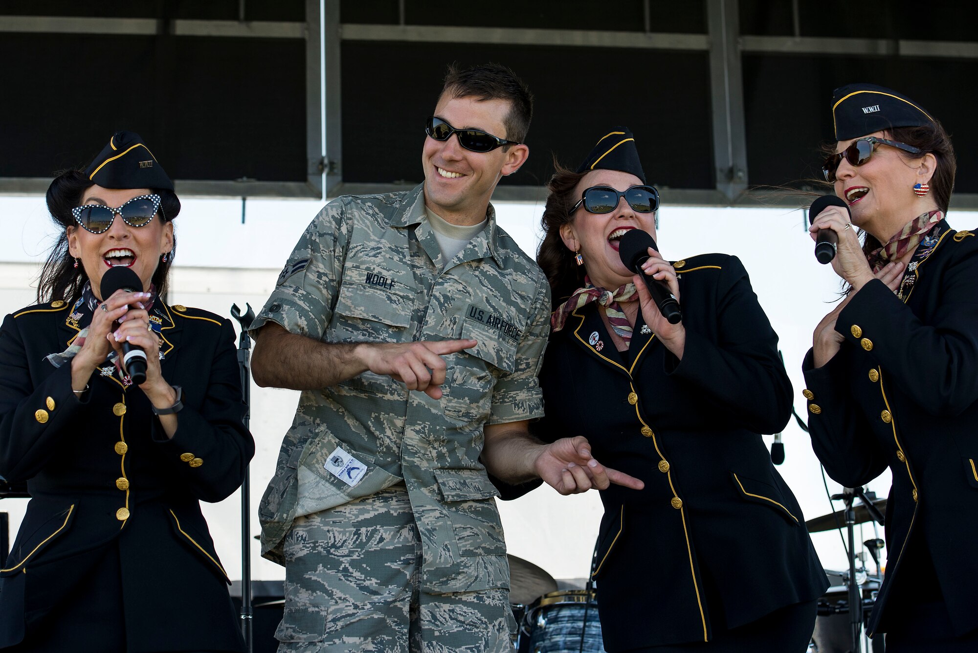 The Ladies for Liberty sing a song with Airman 1st Class Jim Woolf, Band of Mid-America audio engineer, during the Scott Airshow and Open House at Scott Air Force Base, Ill., June 11, 2017. Ladies for Liberty is a singing troupe dedicated to performing the Andrew Sisters style of music through their own rendition of vocals, costumes, hairstyles, and the spirit of patriotism reminiscent of the 1940s. (U.S. Air Force photo by Tech. Sgt. Jonathan Fowler)