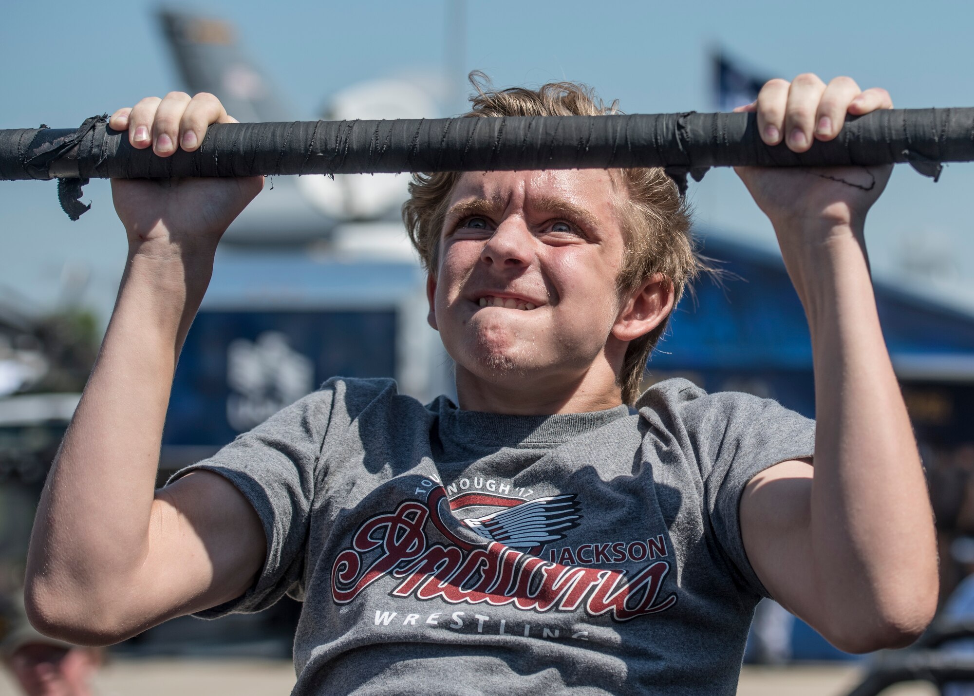 A boy attempts to complete 15 pullups at the recruiting station during the Scott Air Force Base Air Show, Scott Air Force Base, Ill., June 11, 2017. The base hosted the air show and open house to celebrate the 100th year of Scott AFB.  Over 50 aircraft, ranging from WWI’s Curtiss JN-4 Jenny to the currently utilized KC-135 Stratotanker, came to Scott, the fourth oldest Air Force base. Demonstrations included the Black Daggers, “Tora, Tora, Tora,” and the USAF Thunderbirds. Opened in 1917 and previously named Scott Field, the base has seen its mission evolve and expand to encompass a multitude of priorities, including aeromedical evacuation and communications.  Today, Scott is home to 31 mission partners and provides around-the-clock logistics support and rapid global mobility, carried out primarily by U.S. Transportation Command and Air Mobility Command.