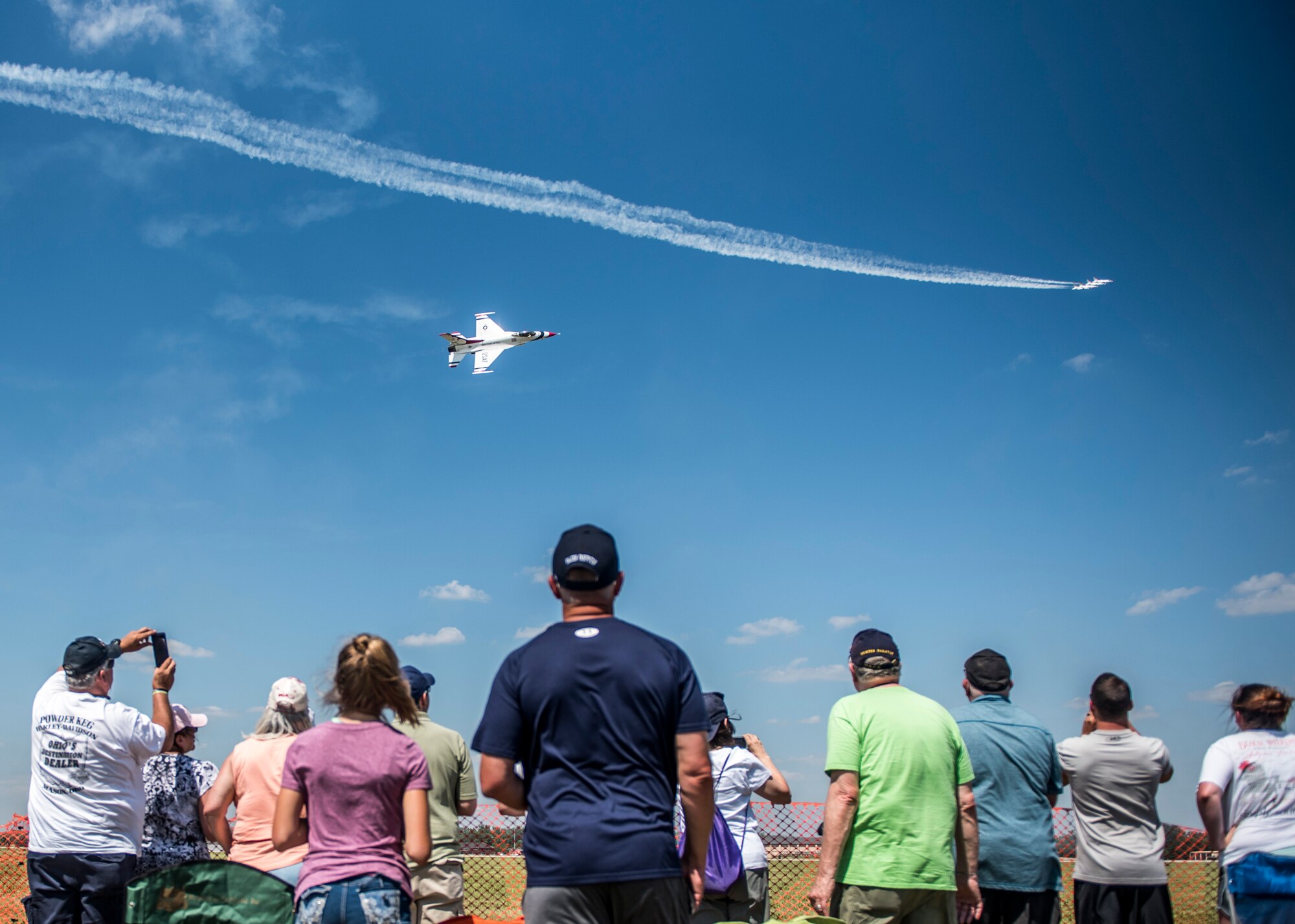 The crowd watched the Thunderbirds performance during the Scott Air Force Base Air Show, Scott Air Force Base, Ill., June 11, 2017. The base hosted the air show and open house to celebrate the 100th year of Scott AFB.  Over 50 aircraft, ranging from WWI’s Curtiss JN-4 Jenny to the currently utilized KC-135 Stratotanker, came to Scott, the fourth oldest Air Force base. Demonstrations included the Black Daggers, “Tora, Tora, Tora,” and the USAF Thunderbirds. Opened in 1917 and previously named Scott Field, the base has seen its mission evolve and expand to encompass a multitude of priorities, including aeromedical evacuation and communications.  Today, Scott is home to 31 mission partners and provides around-the-clock logistics support and rapid global mobility, carried out primarily by U.S. Transportation Command and Air Mobility Command.