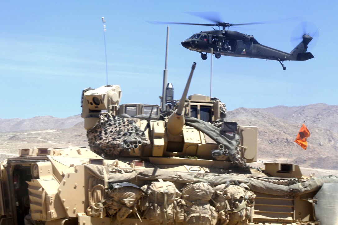 A UH-60 Black Hawk helicopter flies over tactical vehicles during a live-fire exercise at the National Training Center at Fort Irwin, Calif., June 9, 2017. Mississippi National Guard photo by Spc. Justin Humphreys