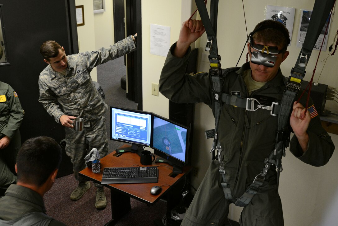U.S. Air Force Cadet 2nd Class Michael Triner, U.S. Air Force Academy cadet, hangs in a harness while others watch a display at Shaw Air Force Base, S.C., June 12, 2017. Triner and other cadets participated in hanging harness training using a virtual reality headset to learn how to safely navigate a parachute during their visit as part of the Operation Air Force program. (U.S. Air Force Airman 1st Class Kathryn R.C. Reaves)