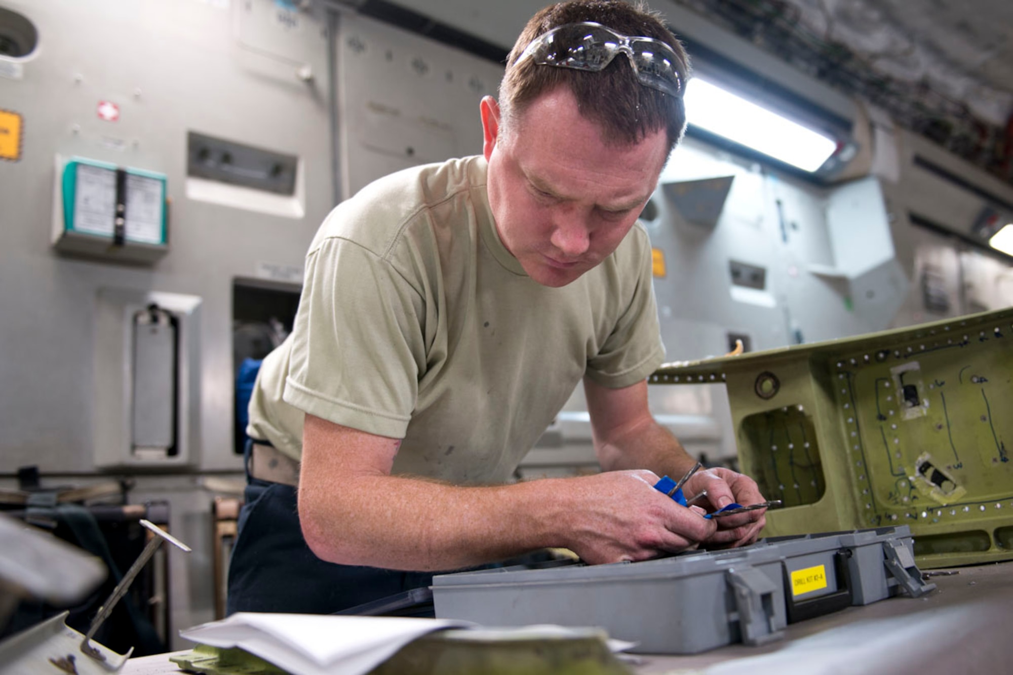 Tech. Sgt. Anthony Scolaro, an aircraft structural maintenance technician, references technical specifications as he looks for a tool while completing a repair on a jack support box for a C-17 Globemaster III aircraft, May 15, at the 167th Airlift Wing.(U.S. Air National Guard photo by Senior Master Sgt. Emily Beightol-Deyerle)