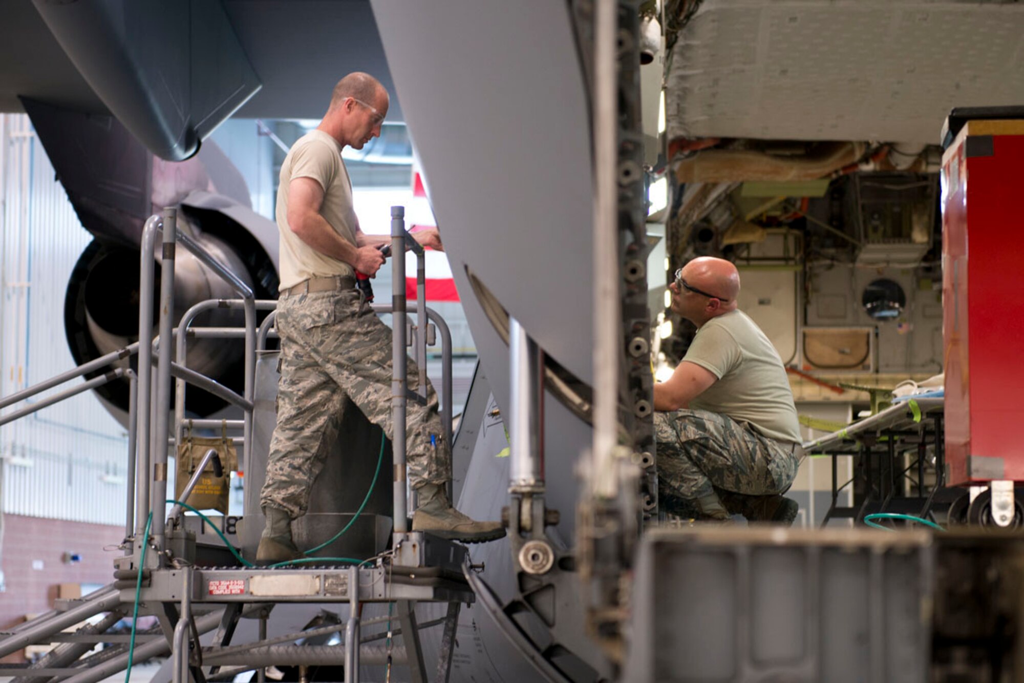 Staff Sgt. Doug Miller and Master Sgt. Scott Dolese, aircraft structural maintenance technicians, work a jack support box repair from the inside and outside of a C-17 Globemaster III aircraft, May 17 at the 167th Airlift Wing. (U.S. Air National Guard phtoo by Senior Master Sgt. Emily Beightol-Deyerle)