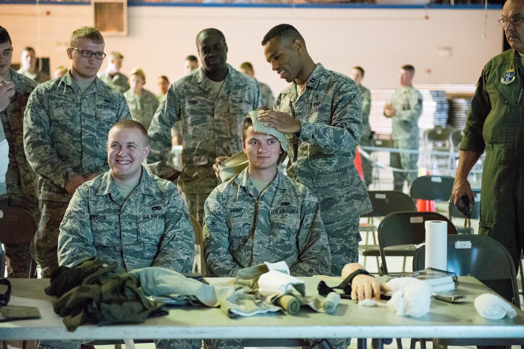 Capt. Jumaane Green (far right), a Chaplin at the 167th Airlift Wing in Martinsburg, W.Va., wraps the head of Airman 1st Class Daniel Frantz (middle), a member of the 167th, while Airman 1st Class Shawn Mcmahon (left) waits his turn during Self Aide Buddy Care (SABC) training, June 9, 2017. A training rodeo, set up by base training, members were able to complete the required Self Aide Buddy Care (SABC), Law of Armed Conflict and Chemical Biological Radiological and Explosive training. (U.S. Air National Guard photo by Staff Sgt. Jodie Witmer)